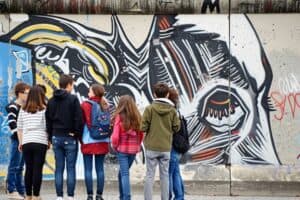 Kinder stehen in Berlin vor der Berliner Mauer