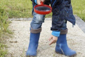 Schüler hält Lupe in der Hand